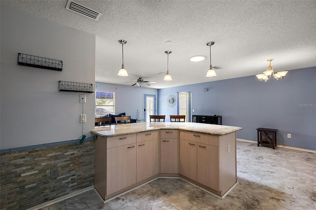 2003 Cordero Ct, The Villages, FL 32159 - kitchen with a textured ceiling, light brown cabinetry, a chandelier, pendant lighting, and a ceiling fan