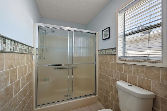 2003 Cordero Ct, The Villages, FL 32159 - bathroom with tile walls, a shower stall, wainscoting, and a textured ceiling