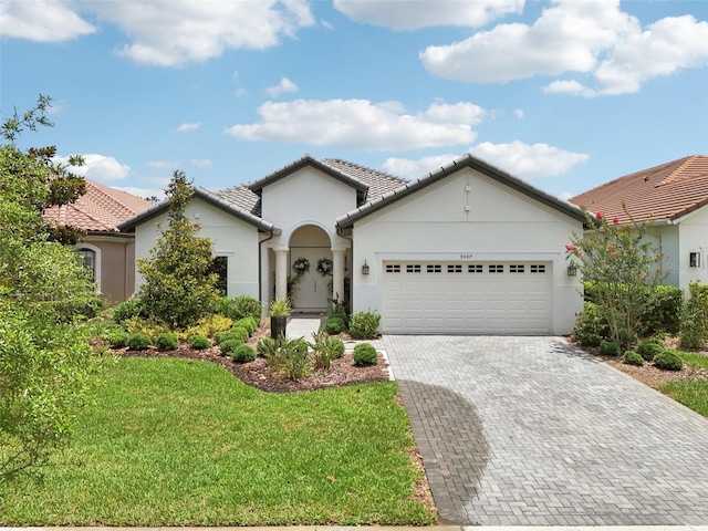 9307 San Jose Blvd, Howey In The Hills, FL 34737 - ranch-style home featuring an attached garage, stucco siding, a front yard, decorative driveway, and a tile roof