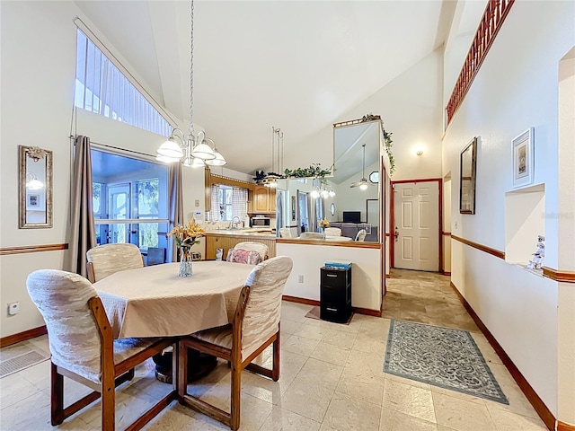 1107 Northshore Dr, Eustis, FL 32726 - dining space with high vaulted ceiling, a chandelier, and baseboards