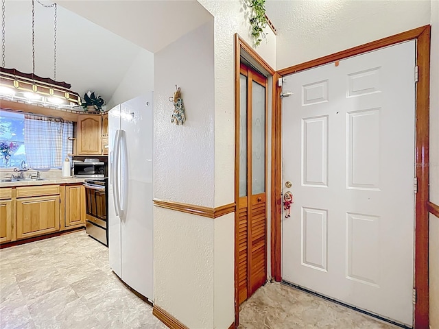 1107 Northshore Dr, Eustis, FL 32726 - kitchen with appliances with stainless steel finishes, light countertops, a textured wall, a sink, and lofted ceiling