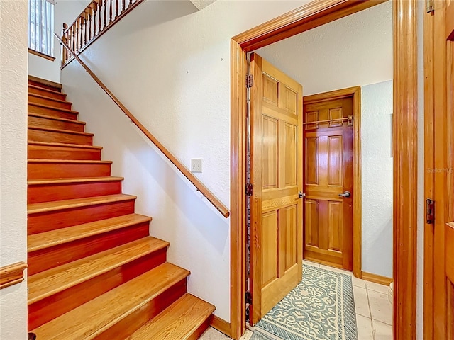1107 Northshore Dr, Eustis, FL 32726 - staircase featuring tile patterned flooring, a textured wall, and baseboards