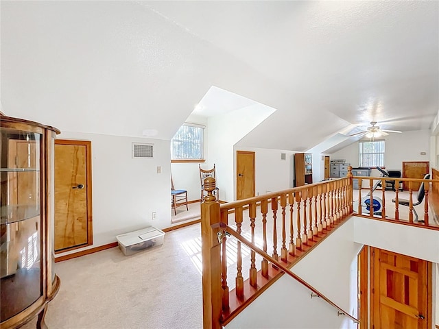 1107 Northshore Dr, Eustis, FL 32726 - hallway featuring vaulted ceiling, plenty of natural light, an upstairs landing, and light carpet