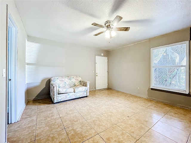 1107 Northshore Dr, Eustis, FL 32726 - sitting room featuring ceiling fan, light tile patterned floors, a textured ceiling, and baseboards