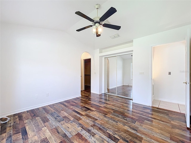 2024 Meadowside Dr, Eustis, FL 32726 - unfurnished bedroom with wood finished floors, arched walkways, vaulted ceiling, a closet, and a ceiling fan