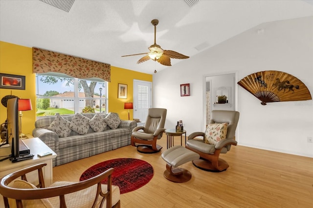 living room with wood finished floors, a ceiling fan, and vaulted ceiling