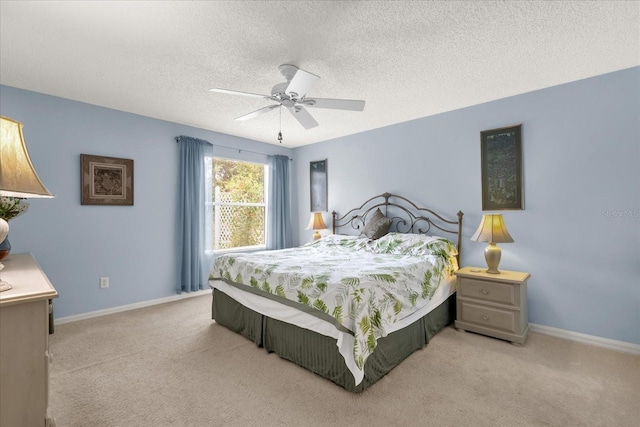 carpeted bedroom featuring a textured ceiling, ceiling fan, and baseboards