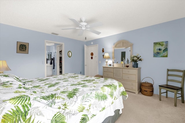 bedroom featuring light colored carpet, a ceiling fan, a walk in closet, and a closet