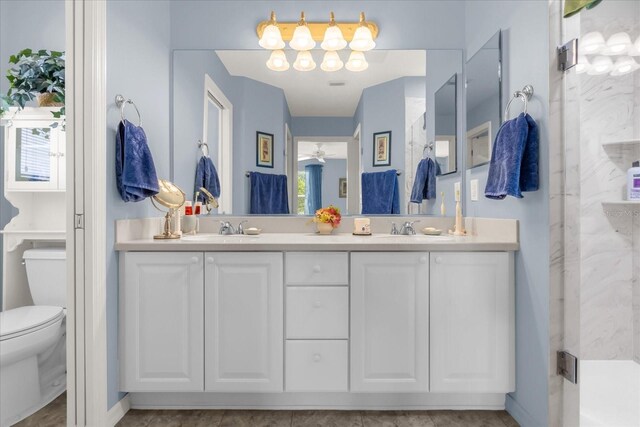 full bath with a stall shower, double vanity, and toilet