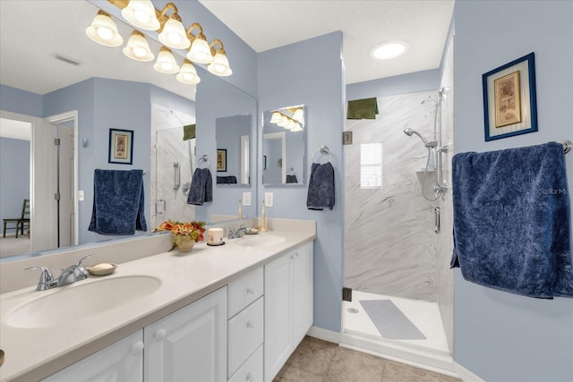 bathroom with a shower stall, double vanity, and tile patterned floors