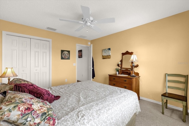 bedroom with a closet, light carpet, ceiling fan, and baseboards