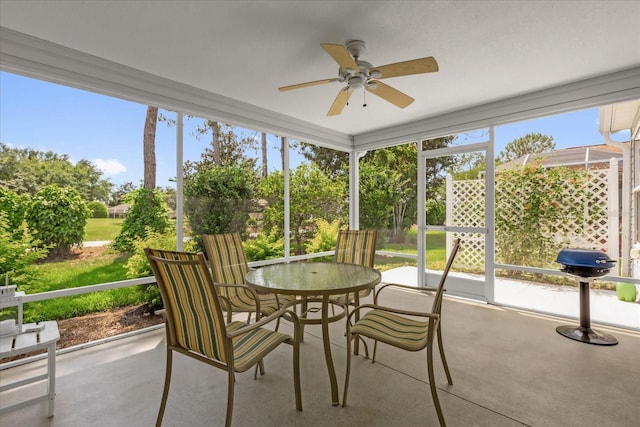 sunroom / solarium with a ceiling fan and outdoor dining area