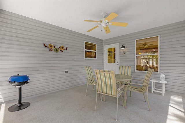 sunroom / solarium with ceiling fan and outdoor dining space