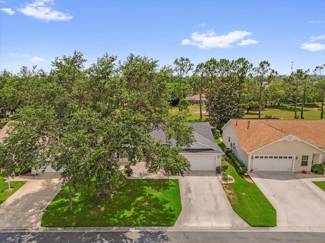 view of front of property featuring driveway, a garage, and a front lawn