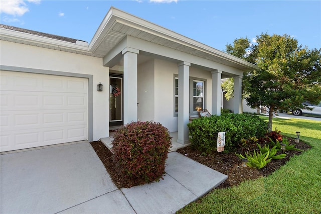 2928 Marlberry Ln, Clermont, FL 34714 - view of exterior entry featuring stucco siding, a garage, driveway, and a yard