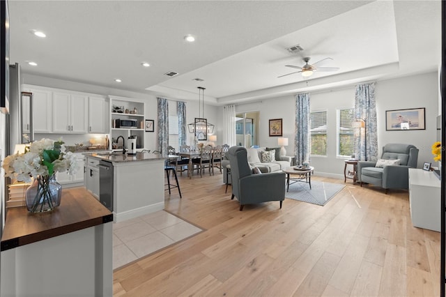2928 Marlberry Ln, Clermont, FL 34714 - living room featuring a raised ceiling, recessed lighting, light wood-style floors, and ceiling fan