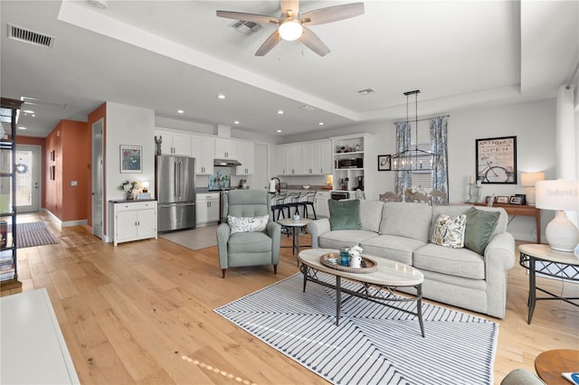 2928 Marlberry Ln, Clermont, FL 34714 - living room featuring a raised ceiling, a ceiling fan, light wood finished floors, recessed lighting, and baseboards