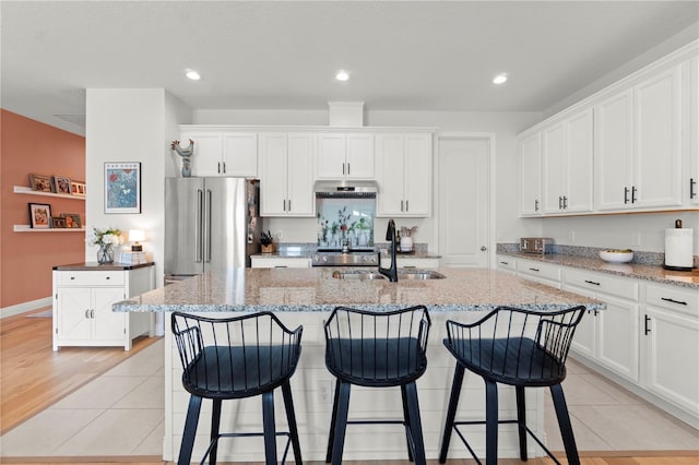 2928 Marlberry Ln, Clermont, FL 34714 - kitchen with a sink, under cabinet range hood, high quality fridge, white cabinetry, and recessed lighting