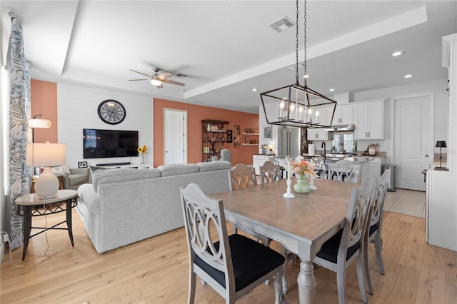 2928 Marlberry Ln, Clermont, FL 34714 - dining room with light wood-style floors, ceiling fan, a tray ceiling, recessed lighting, and a chandelier