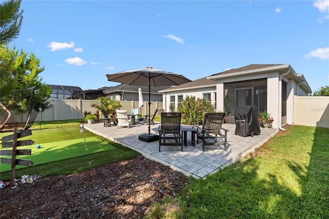 2928 Marlberry Ln, Clermont, FL 34714 - rear view of house featuring a putting green, a patio area, a sunroom, and stucco siding