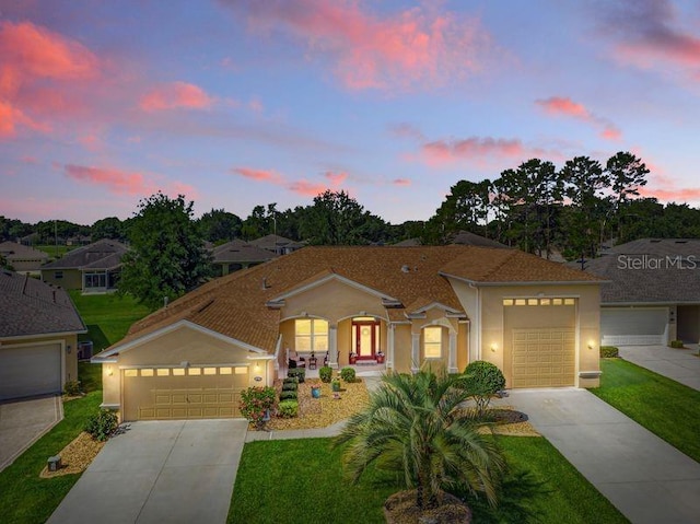 4716 Heritage Trl, Leesburg, FL 34748 - view of front of house with driveway, a lawn, stucco siding, and an attached garage