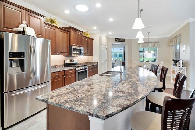 4716 Heritage Trl, Leesburg, FL 34748 - kitchen featuring appliances with stainless steel finishes, a sink, crown molding, a kitchen bar, and arched walkways
