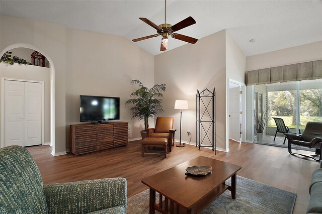 25406 Crestwater Dr, Leesburg, FL 34748 - living area featuring wood finished floors, ceiling fan, baseboards, and high vaulted ceiling