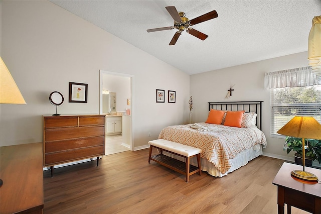25406 Crestwater Dr, Leesburg, FL 34748 - bedroom with wood finished floors, baseboards, a textured ceiling, high vaulted ceiling, and ensuite bath