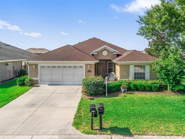 10986 SE 171st Street Rd, Summerfield, FL 34491 - view of front of house with stucco siding, an attached garage, a front yard, and concrete driveway
