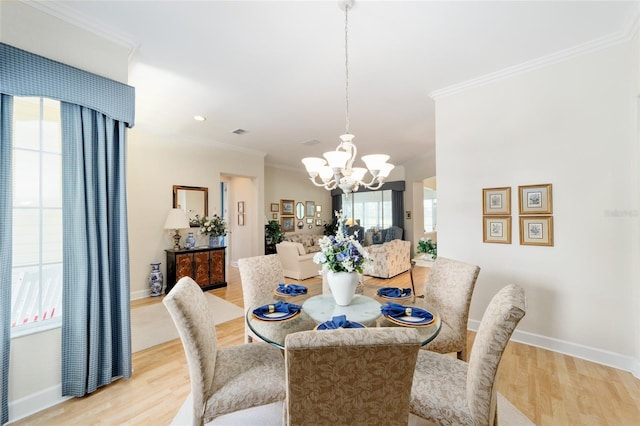 13165 SE 93rd Cir, Summerfield, FL 34491 - dining room with a chandelier, light wood finished floors, crown molding, and baseboards