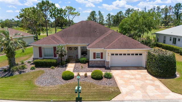 13165 SE 93rd Cir, Summerfield, FL 34491 - view of front of house featuring a garage, driveway, a front lawn, covered porch, and roof with shingles