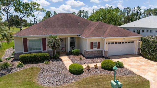 13165 SE 93rd Cir, Summerfield, FL 34491 - view of front of house featuring a garage, concrete driveway, brick siding, a shingled roof, and a front yard
