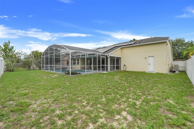 2896 Picadilly Cir, Kissimmee, FL 34747 - back of property with stucco siding, an outdoor pool, roof mounted solar panels, and glass enclosure