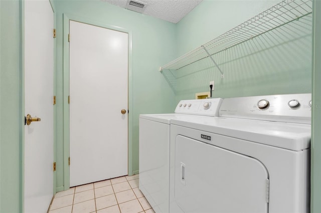 2896 Picadilly Cir, Kissimmee, FL 34747 - laundry area with washer and clothes dryer, light tile patterned flooring, and a textured ceiling