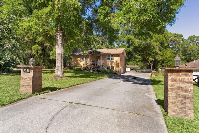5581 SW 197th Ter, Dunnellon, FL 34431 - view of front facade with driveway, a front yard, and view of scattered trees