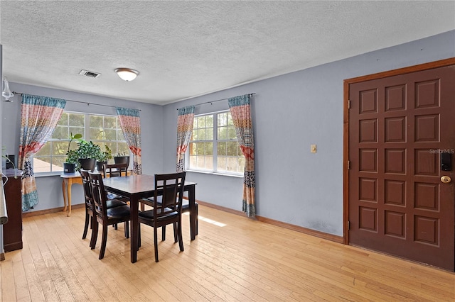 5581 SW 197th Ter, Dunnellon, FL 34431 - dining space featuring light wood-type flooring, baseboards, and a textured ceiling