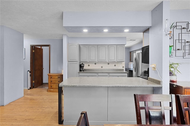 5581 SW 197th Ter, Dunnellon, FL 34431 - kitchen featuring freestanding refrigerator, a peninsula, light wood-type flooring, light countertops, and recessed lighting
