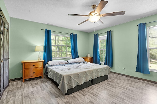 5581 SW 197th Ter, Dunnellon, FL 34431 - bedroom with wood finished floors, baseboards, multiple windows, and a textured ceiling