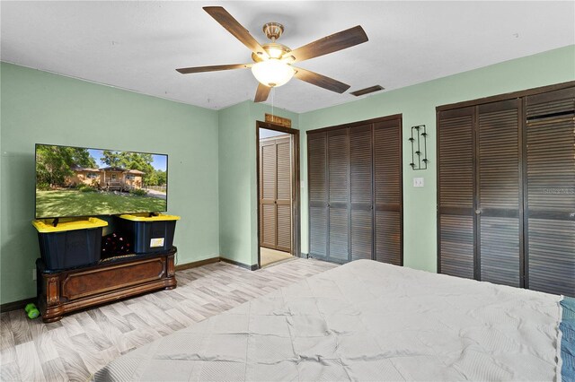 5581 SW 197th Ter, Dunnellon, FL 34431 - bedroom with two closets, baseboards, light wood-style floors, and ceiling fan