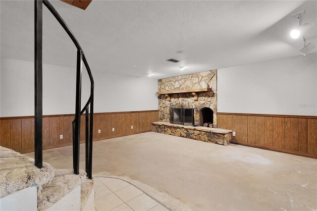 5581 SW 197th Ter, Dunnellon, FL 34431 - unfurnished living room featuring wood walls, a wainscoted wall, a fireplace, and concrete floors