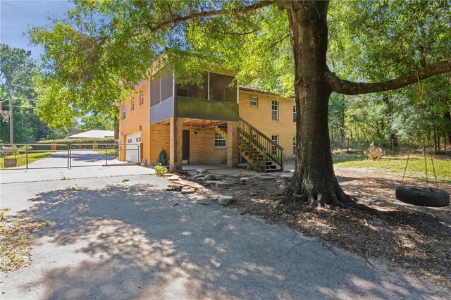 5581 SW 197th Ter, Dunnellon, FL 34431 - view of front facade with driveway, a sunroom, stairway, and an attached garage