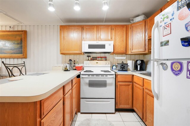 10301 US Highway 27 Unit 187, Clermont, FL 34711 - kitchen with white appliances, light tile patterned floors, a peninsula, and light countertops