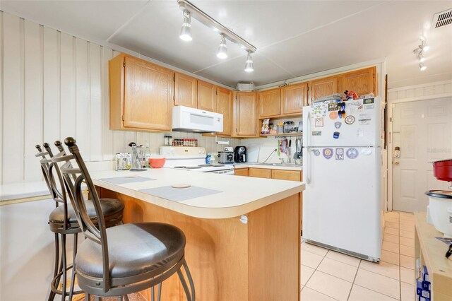 10301 US Highway 27 Unit 187, Clermont, FL 34711 - kitchen with white appliances, track lighting, a peninsula, light countertops, and light tile patterned floors