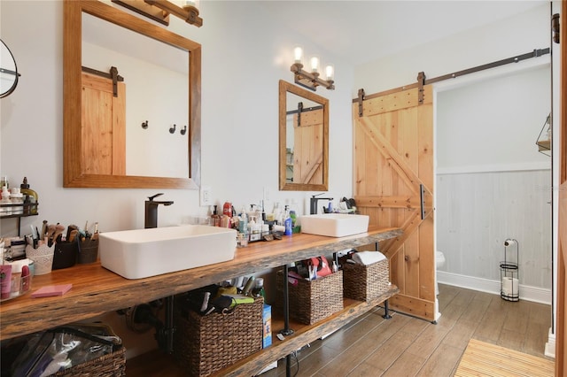 1226 Overlook Rd, Eustis, FL 32726 - bathroom featuring wood finished floors, toilet, double vanity, and baseboards