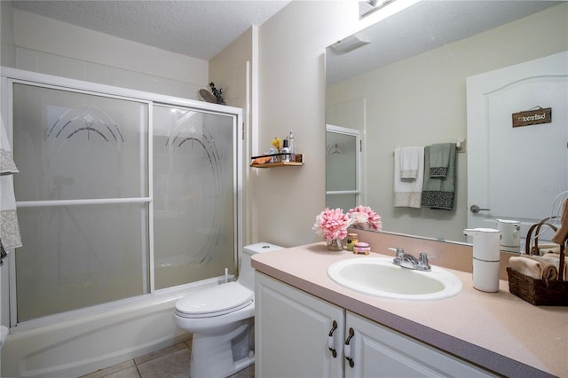 11036 Bronson Rd, Clermont, FL 34711 - full bath with vanity, tile patterned floors, combined bath / shower with glass door, and a textured ceiling