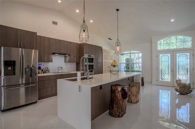 11036 Bronson Rd, Clermont, FL 34711 - kitchen with stainless steel appliances, high vaulted ceiling, light tile patterned floors, light countertops, and a center island with sink