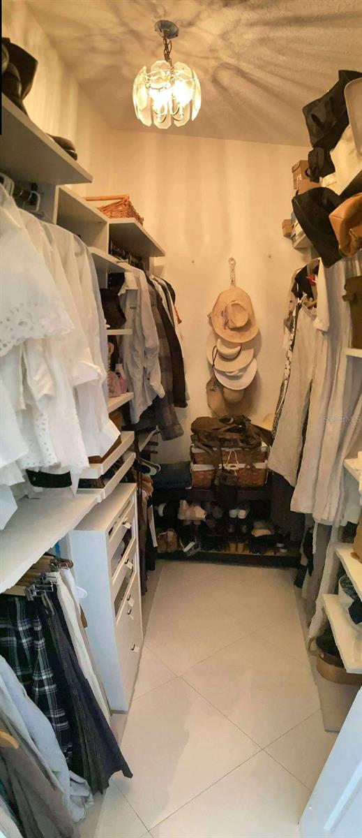 11036 Bronson Rd, Clermont, FL 34711 - walk in closet featuring tile patterned flooring and a chandelier