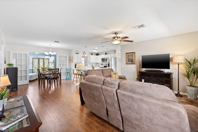 612 Lisbon Ln, The Villages, FL 32159 - living area with a chandelier, ceiling fan, dark wood finished floors, and a textured ceiling