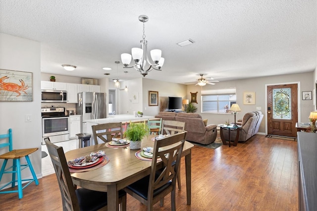 612 Lisbon Ln, The Villages, FL 32159 - dining area with a chandelier, a ceiling fan, a textured ceiling, and wood finished floors