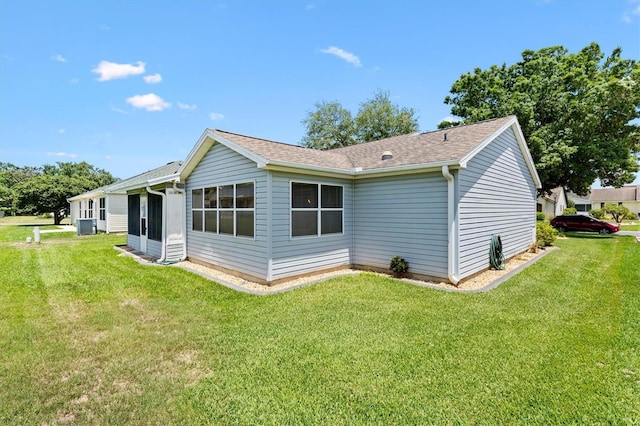 612 Lisbon Ln, The Villages, FL 32159 - rear view of house featuring a yard, cooling unit, and a shingled roof